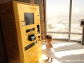 A little girl using gold vending machine to buy gold
